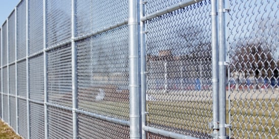 Galvanized chain link security fence installed around a protected property.