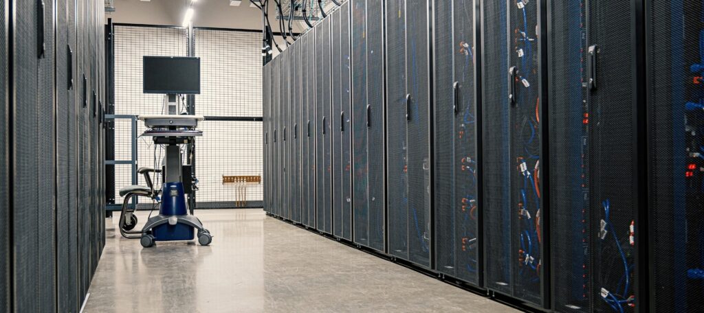 Interior of a secure data center with reinforced fencing and server racks.