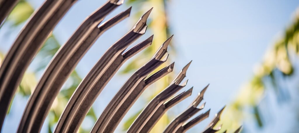 Close-up of anti-climb security fence spikes protecting a government facility.