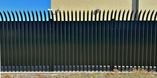 Ornamental iron security fence with anti-climb design installed around a protected facility.